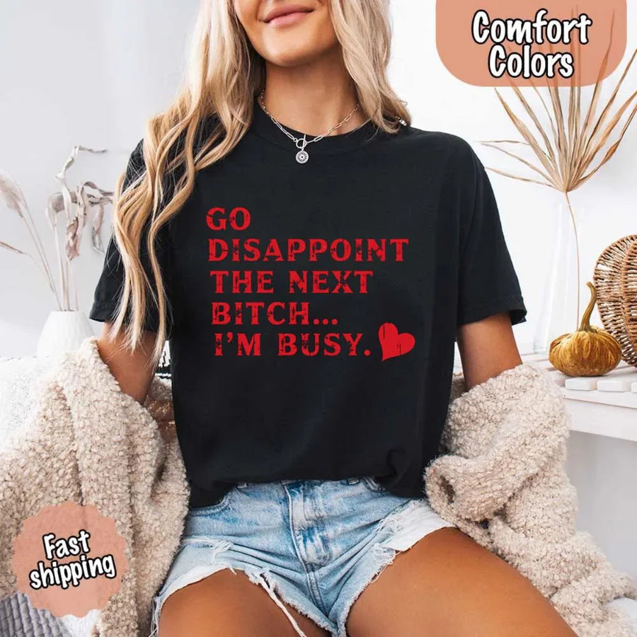 May include bold red distressed typography with the phrase “Go Disappoint The Next Bitch… I’m Busy.” alongside a red heart, expressing sass, confidence, and attitude.
