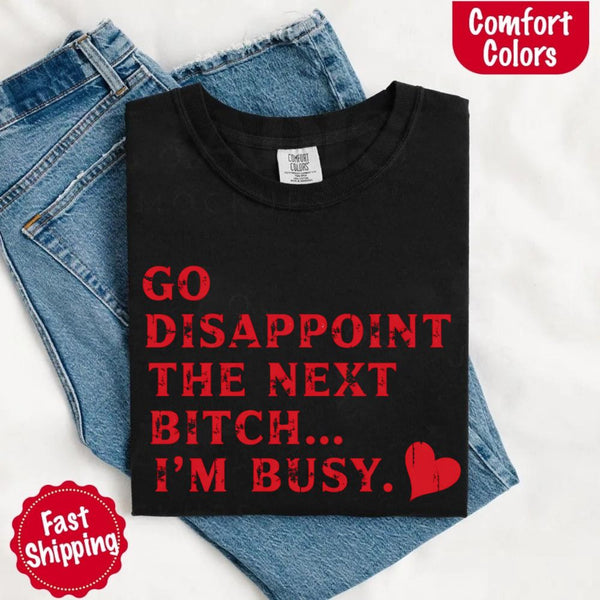 May include bold red distressed typography with the phrase “Go Disappoint The Next Bitch… I’m Busy.” alongside a red heart, expressing sass, confidence, and attitude.