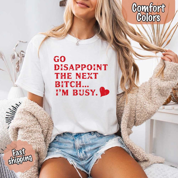 May include bold red distressed typography with the phrase “Go Disappoint The Next Bitch… I’m Busy.” alongside a red heart, expressing sass, confidence, and attitude.