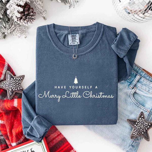 May include a Comfort Colors long sleeve shirt featuring the phrase “Have Yourself a Merry Christmas” in festive print, displayed flat with soft cotton texture and seasonal tones.