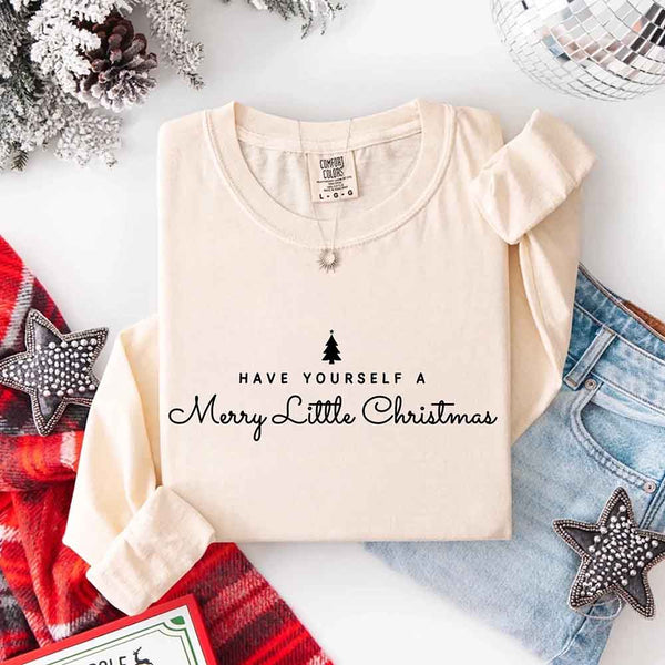 May include a Comfort Colors long sleeve shirt featuring the phrase “Have Yourself a Merry Christmas” in festive print, displayed flat with soft cotton texture and seasonal tones.