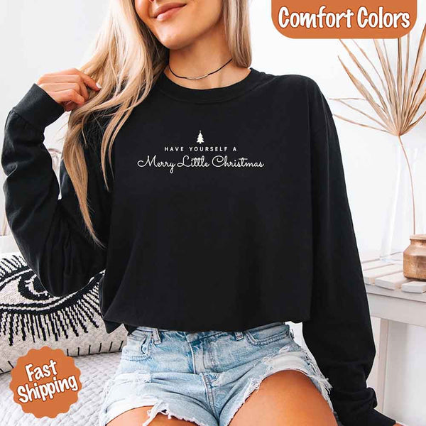 May include a Comfort Colors long sleeve shirt featuring the phrase “Have Yourself a Merry Christmas” in festive print, displayed flat with soft cotton texture and seasonal tones.