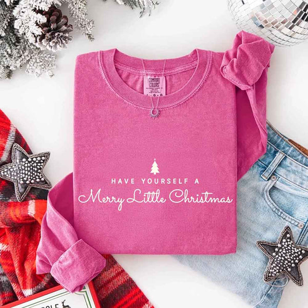 May include a Comfort Colors long sleeve shirt featuring the phrase “Have Yourself a Merry Christmas” in festive print, displayed flat with soft cotton texture and seasonal tones.