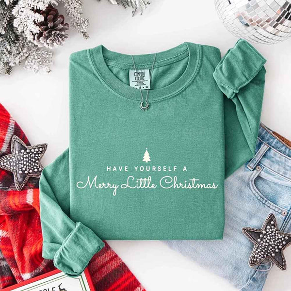 May include a Comfort Colors long sleeve shirt featuring the phrase “Have Yourself a Merry Christmas” in festive print, displayed flat with soft cotton texture and seasonal tones.