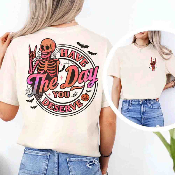 May include skeleton Halloween graphic with holographic lettering ‘Have the Day You Deserve,’ skeleton hand gesture, bats, spider webs, and pumpkin accent – spooky graphic tee design.
