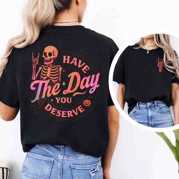 May include skeleton Halloween graphic with holographic lettering ‘Have the Day You Deserve,’ skeleton hand gesture, bats, spider webs, and pumpkin accent – spooky graphic tee design.