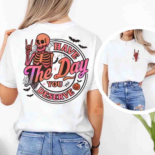 May include skeleton Halloween graphic with holographic lettering ‘Have the Day You Deserve,’ skeleton hand gesture, bats, spider webs, and pumpkin accent – spooky graphic tee design.