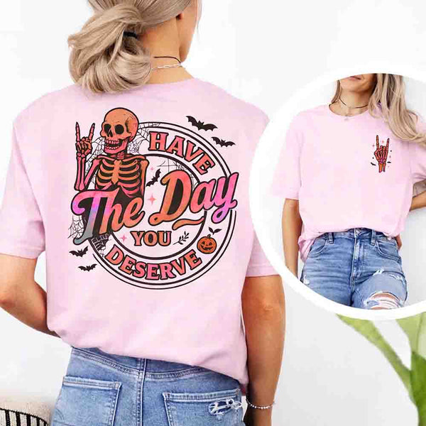 May include skeleton Halloween graphic with holographic lettering ‘Have the Day You Deserve,’ skeleton hand gesture, bats, spider webs, and pumpkin accent – spooky graphic tee design.