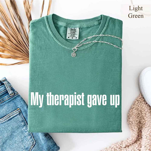 May include a Comfort Colors short-sleeve shirt with the printed phrase My Therapist Gave Up in a simple, bold design.