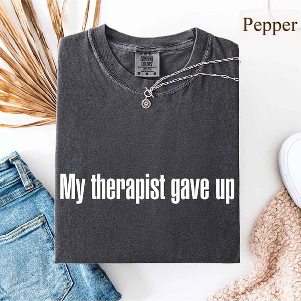 May include a Comfort Colors short-sleeve shirt with the printed phrase My Therapist Gave Up in a simple, bold design.