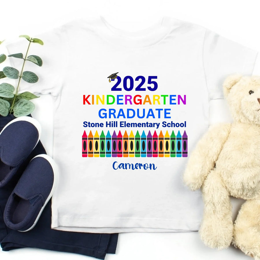 May include colorful text that reads “2025 KINDERGARTEN GRADUATE Stone Hill Elementary School” with a graduation cap over the number “2.” The word "KINDERGARTEN" is in rainbow colors, and the image features a row of multicolored crayons, celebrating a young student’s graduation.
