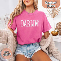May include bold black distressed Western-style typography featuring the word “Darlin’,” evoking country charm with a vintage, rustic feel.