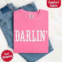 May include bold black distressed Western-style typography featuring the word “Darlin’,” evoking country charm with a vintage, rustic feel.
