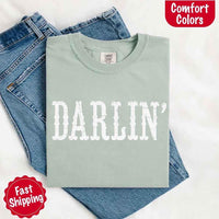 May include bold black distressed Western-style typography featuring the word “Darlin’,” evoking country charm with a vintage, rustic feel.