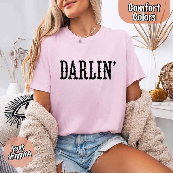 May include bold black distressed Western-style typography featuring the word “Darlin’,” evoking country charm with a vintage, rustic feel.