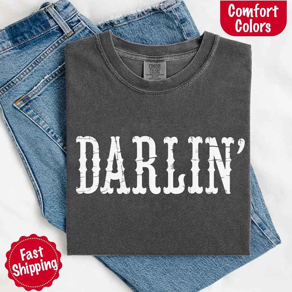 May include bold black distressed Western-style typography featuring the word “Darlin’,” evoking country charm with a vintage, rustic feel.