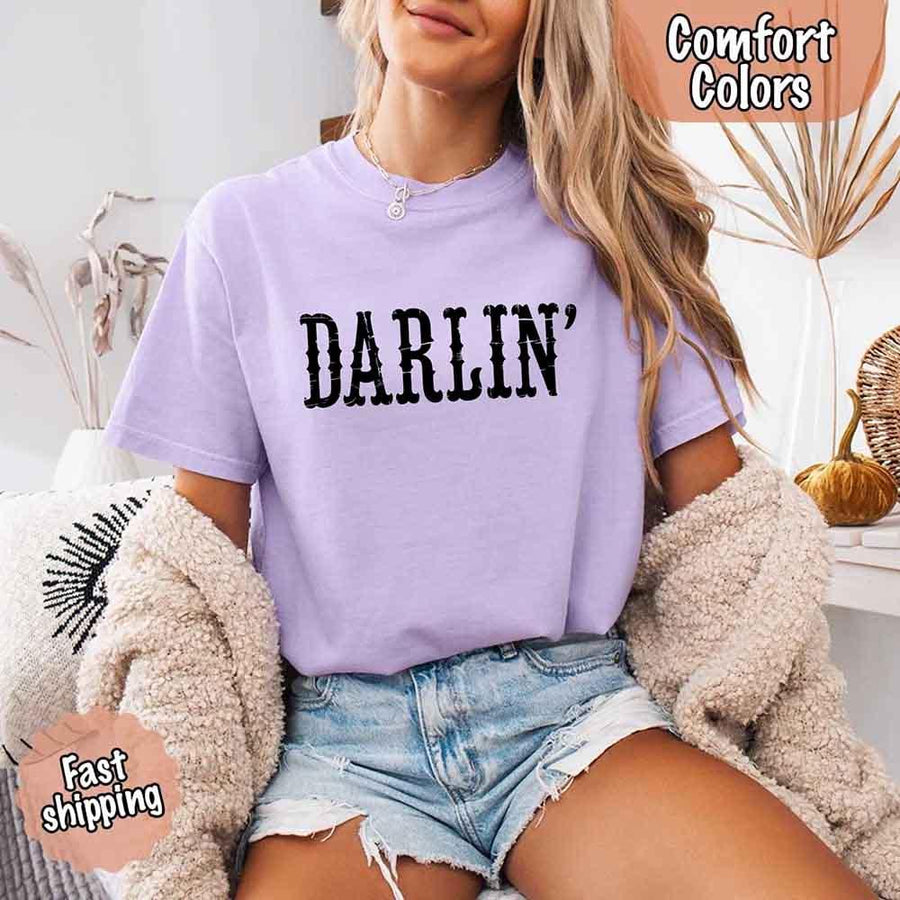 May include bold black distressed Western-style typography featuring the word “Darlin’,” evoking country charm with a vintage, rustic feel.