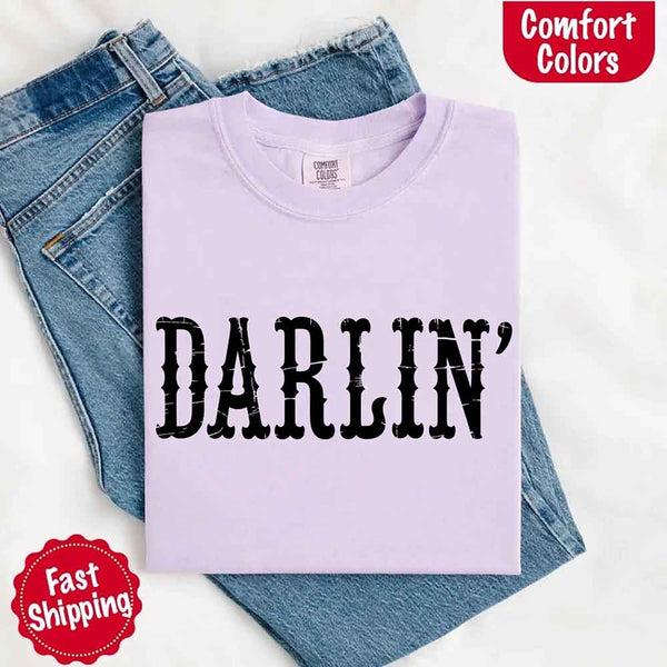 May include bold black distressed Western-style typography featuring the word “Darlin’,” evoking country charm with a vintage, rustic feel.