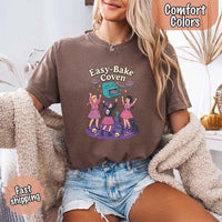 May include Easy Bake Coven graphic with three witch girls baking pies, retro oven, skulls, gravestone, and black cat – vintage 90s Halloween shirt.