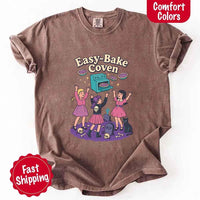 May include Easy Bake Coven graphic with three witch girls baking pies, retro oven, skulls, gravestone, and black cat – vintage 90s Halloween shirt.