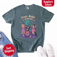May include Easy Bake Coven graphic with three witch girls baking pies, retro oven, skulls, gravestone, and black cat – vintage 90s Halloween shirt.