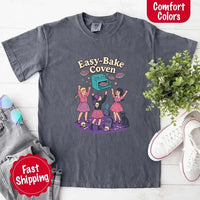 May include Easy Bake Coven graphic with three witch girls baking pies, retro oven, skulls, gravestone, and black cat – vintage 90s Halloween shirt.