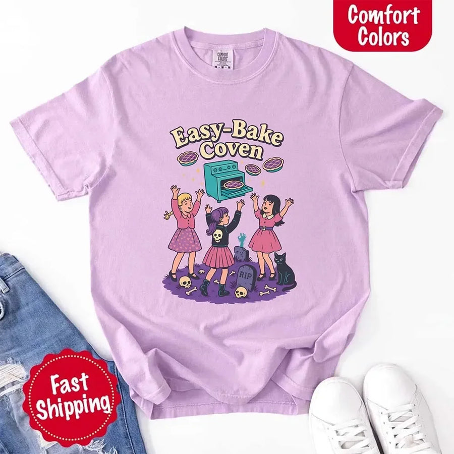 May include Easy Bake Coven graphic with three witch girls baking pies, retro oven, skulls, gravestone, and black cat – vintage 90s Halloween shirt.