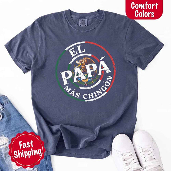 May include bold distressed text that reads “El Papá Más Chingón” over a circular Mexican flag-inspired design with an eagle emblem, celebrating proud and confident fatherhood with cultural pride.