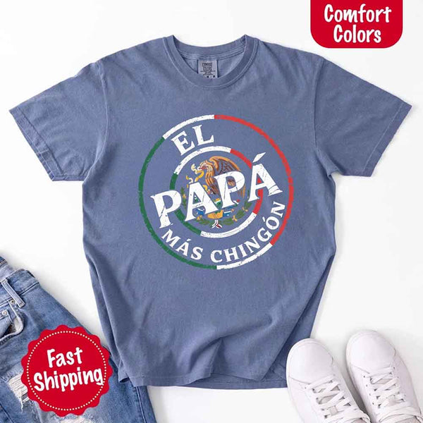 May include bold distressed text that reads “El Papá Más Chingón” over a circular Mexican flag-inspired design with an eagle emblem, celebrating proud and confident fatherhood with cultural pride.