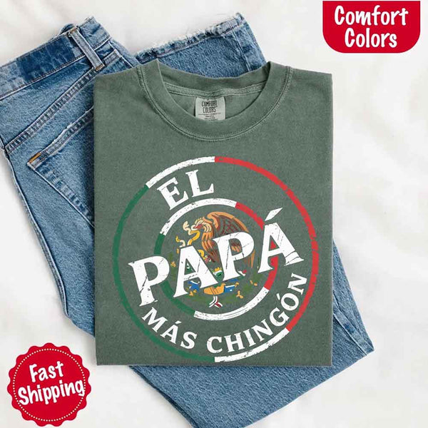 May include bold distressed text that reads “El Papá Más Chingón” over a circular Mexican flag-inspired design with an eagle emblem, celebrating proud and confident fatherhood with cultural pride.