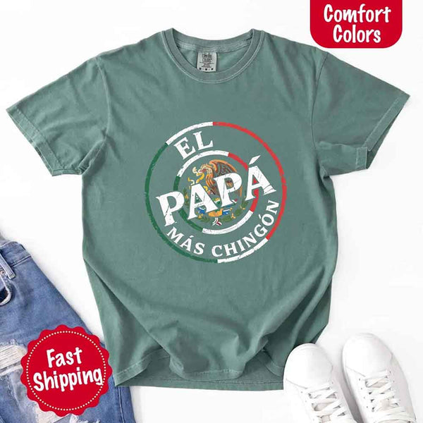 May include bold distressed text that reads “El Papá Más Chingón” over a circular Mexican flag-inspired design with an eagle emblem, celebrating proud and confident fatherhood with cultural pride.