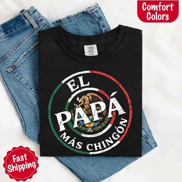 May include bold distressed text that reads “El Papá Más Chingón” over a circular Mexican flag-inspired design with an eagle emblem, celebrating proud and confident fatherhood with cultural pride.