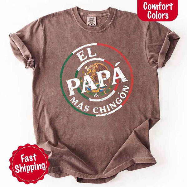 May include bold distressed text that reads “El Papá Más Chingón” over a circular Mexican flag-inspired design with an eagle emblem, celebrating proud and confident fatherhood with cultural pride.
