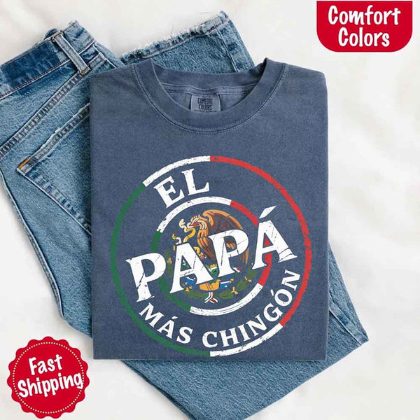 May include bold distressed text that reads “El Papá Más Chingón” over a circular Mexican flag-inspired design with an eagle emblem, celebrating proud and confident fatherhood with cultural pride.