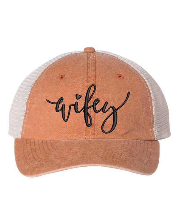 May include an embroidered pigment-dyed trucker hat with mesh back, featuring “Wifey” or “Hubby” text, designed as a casual and stylish gift for spouses or anniversaries.