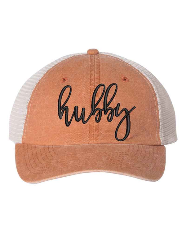 May include an embroidered pigment-dyed trucker hat with mesh back, featuring “Wifey” or “Hubby” text, designed as a casual and stylish gift for spouses or anniversaries.