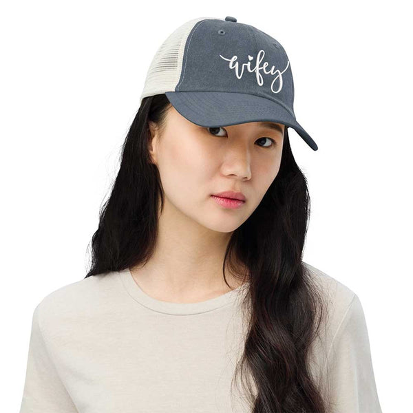 May include an embroidered pigment-dyed trucker hat with mesh back, featuring “Wifey” or “Hubby” text, designed as a casual and stylish gift for spouses or anniversaries.
