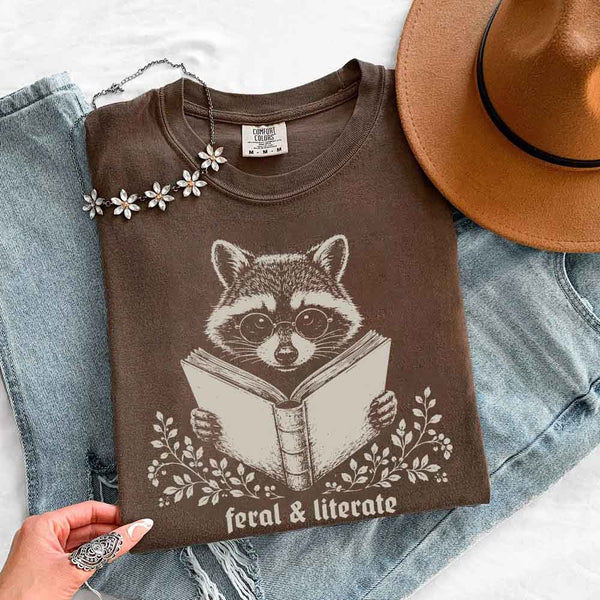 May include Feral & Literate Raccoon Comfort Colors t-shirt with funny book lover graphic, relaxed unisex fit, and garment-dyed cotton