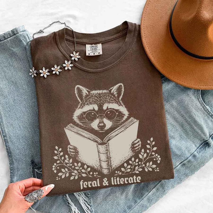 May include Feral & Literate Raccoon Comfort Colors t-shirt with funny book lover graphic, relaxed unisex fit, and garment-dyed cotton