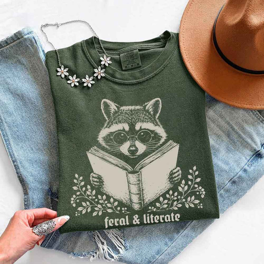 May include Feral & Literate Raccoon Comfort Colors t-shirt with funny book lover graphic, relaxed unisex fit, and garment-dyed cotton