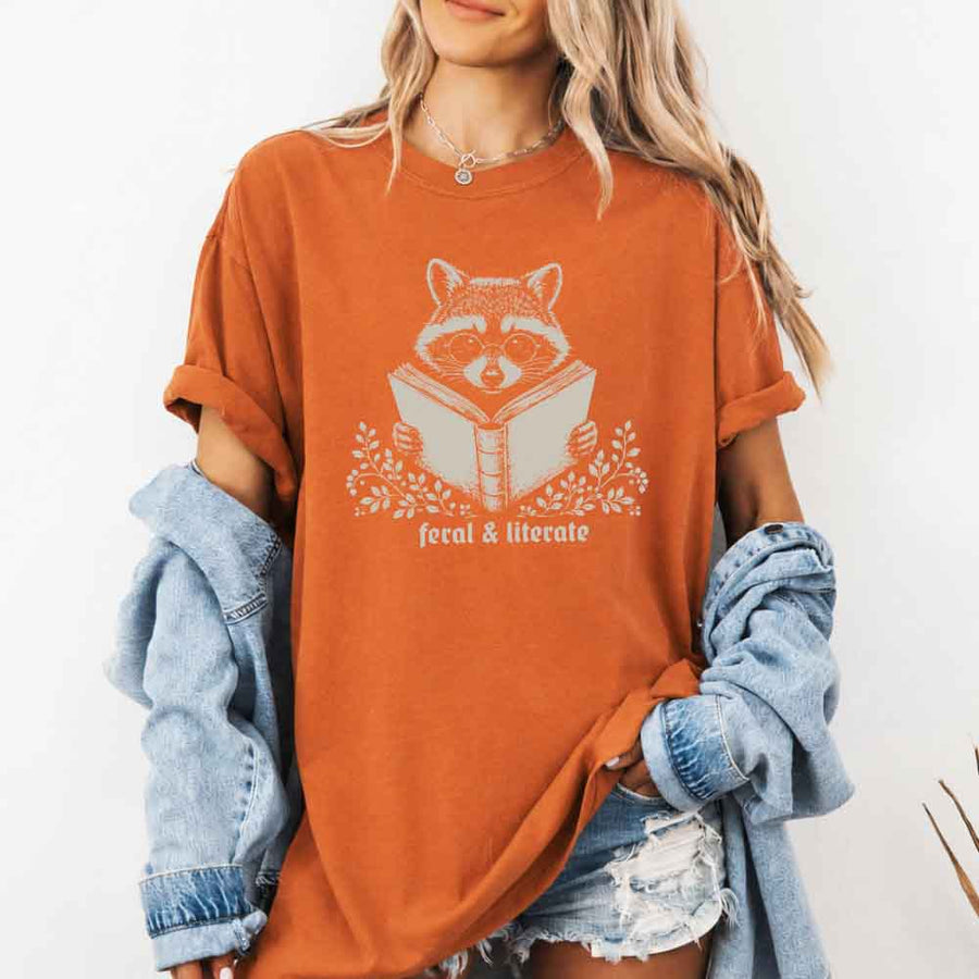May include Feral & Literate Raccoon Comfort Colors t-shirt with funny book lover graphic, relaxed unisex fit, and garment-dyed cotton