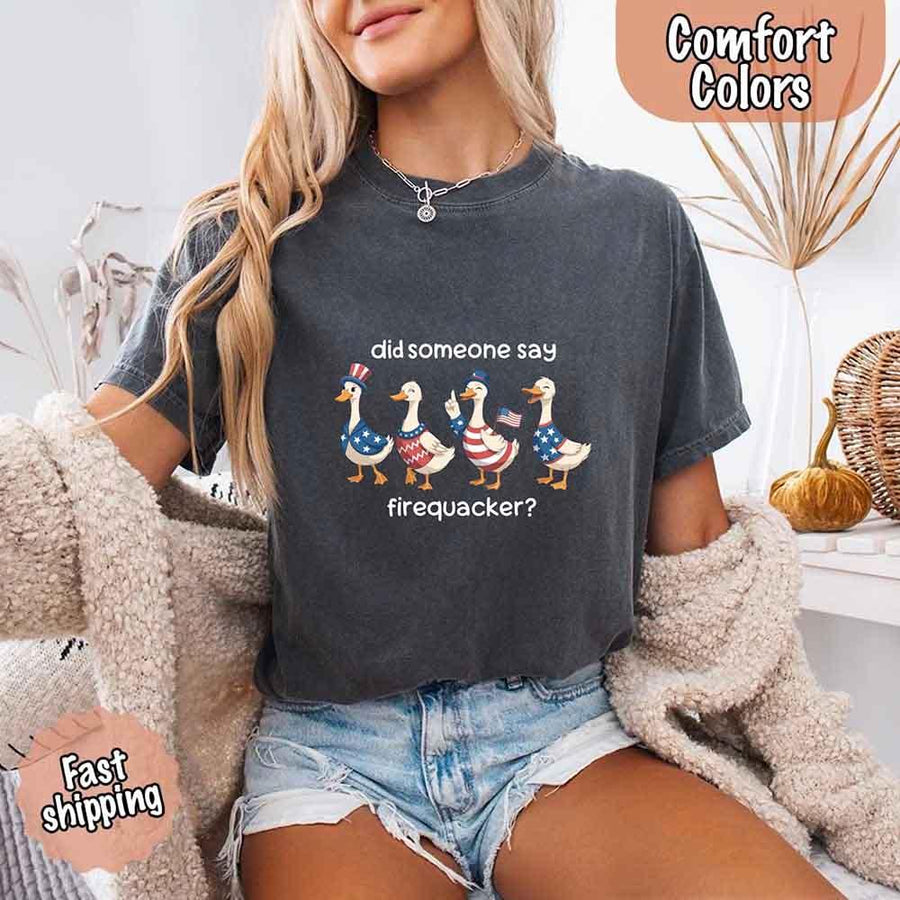 May include a woman wearing a Pepper Comfort Colors t-shirt with a 'Firequacker' goose print — styled with a fun, vintage patriotic vibe perfect for Independence Day.