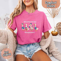 Person wearing a pink t-shirt with a graphic and text, sitting on a couch.