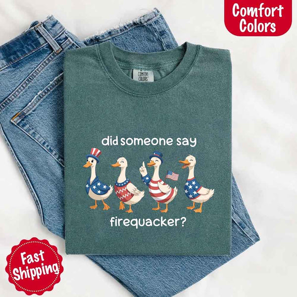 Green t-shirt with graphic of ducks wearing American flags and text 'did someone say firequacker?' on a white background.