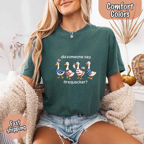 Person wearing a green t-shirt with a graphic and text, sitting on a couch.