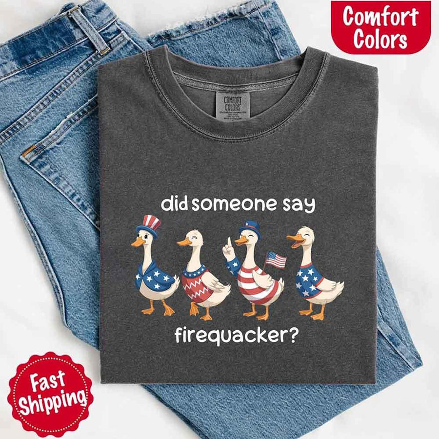 May include a folded pepper Comfort Colors t-shirt featuring a 'Firequacker' goose graphic — a humorous 4th of July design with vintage USA patriotic elements.
