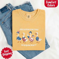 Folded yellow t-shirt with graphic design and text on a white background, featuring jeans.