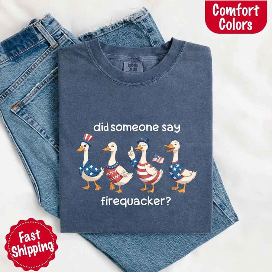 Folded blue t-shirt with graphic design and jeans on a white background
