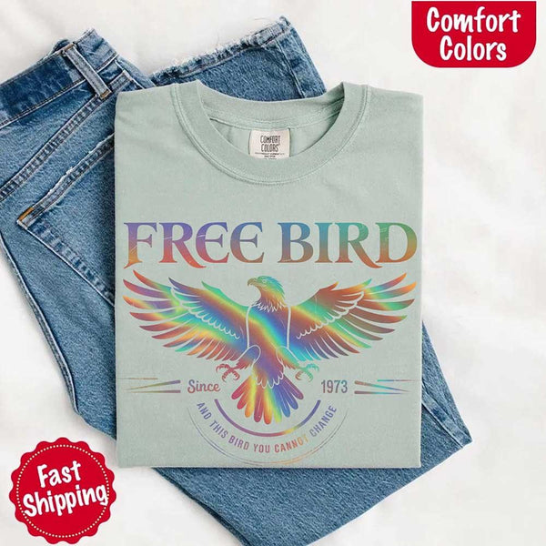 May include a vintage-inspired design with the phrase “Free Bird” on a Comfort Colors tee, channeling classic rock band style and retro music vibes perfect for fans of timeless tunes.