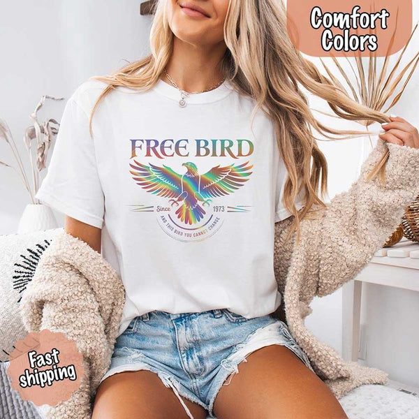 May include a vintage-inspired design with the phrase “Free Bird” on a Comfort Colors tee, channeling classic rock band style and retro music vibes perfect for fans of timeless tunes.